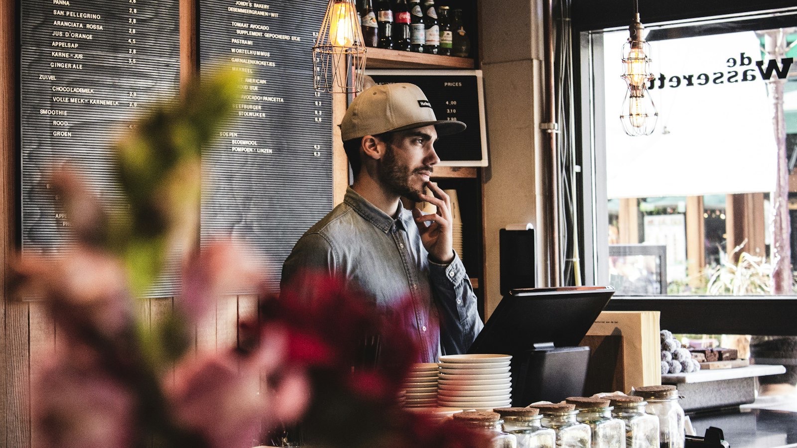 Small cafe owner behind the counter preparing for the morning rush
