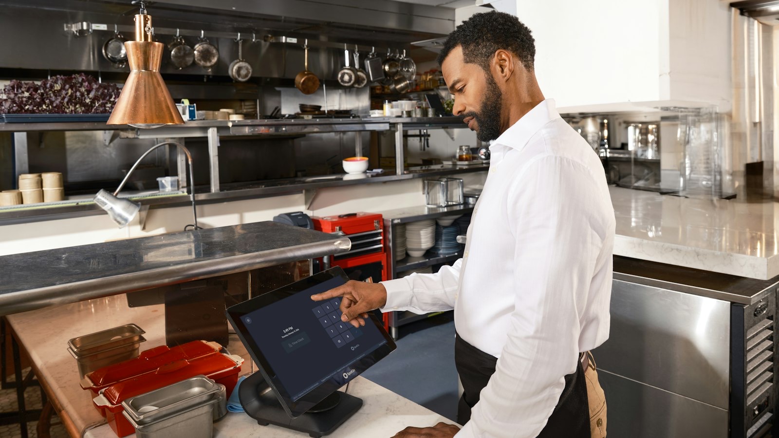 Restaurant manager planning the week's shifts on a tablet before service