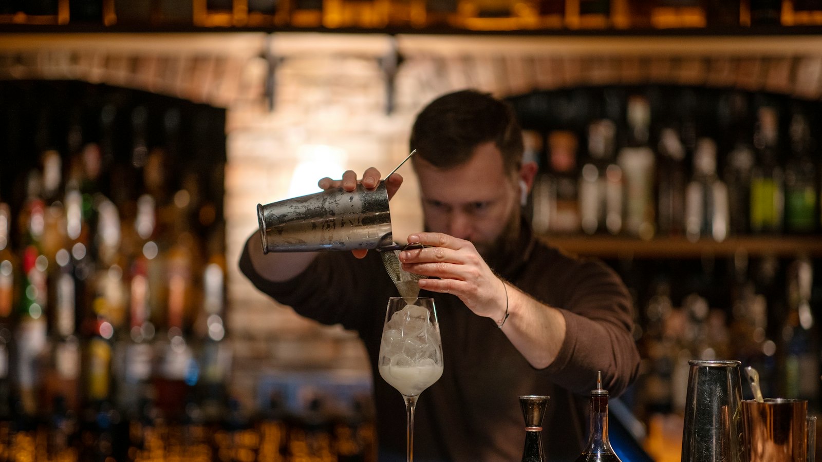 Bartender working behind a busy bar during evening service